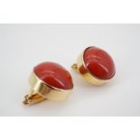 A pair of modern high carat yellow metal and polished red jasper ear clips, of circular section,