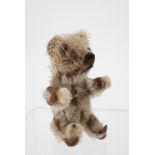 A 1930s Schuco Piccolo miniature Teddy bear, having articulated limbs with felt paws and feet,