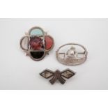 Silver pebble brooches, including a quatrefoil brooch inset with hardstone petals, and a cast silver