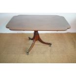 A Regency string-inlaid mahogany snap-top breakfast table, the rounded oblong top having re-