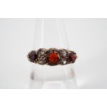 A vintage 9ct gold, garnet and paste dress ring, in a lenticular setting, with central round-cut