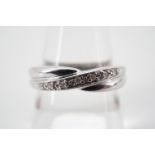 A contemporary 9ct white gold and diamond eternity ring, the face being twist-set in a saltire