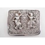 An Indian white metal buckle, repousse moulded with dancing figures, over a scrolling foliate