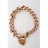 An antique rose yellow-metal curb bracelet with heart-shaped padlock clasp, stamped '9ct' to