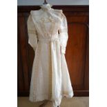 An Edwardian lady's champagne silk two-piece wedding dress, with pouter pigeon bodice, the latter