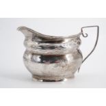 A George V silver cream jug, of Georgian shape, with wriggle-work and engraved decoration, Levi