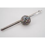 A Russian style cloisonne enamelled white metal bar brooch surmounted by a central bauble, tests