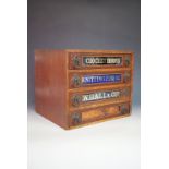 A late 19th Century haberdashery shop mahogany-veneered chest of four drawers, each drawer having