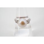 A vintage high carat white metal, diamond and natural saltwater baroque pearl ring, the central