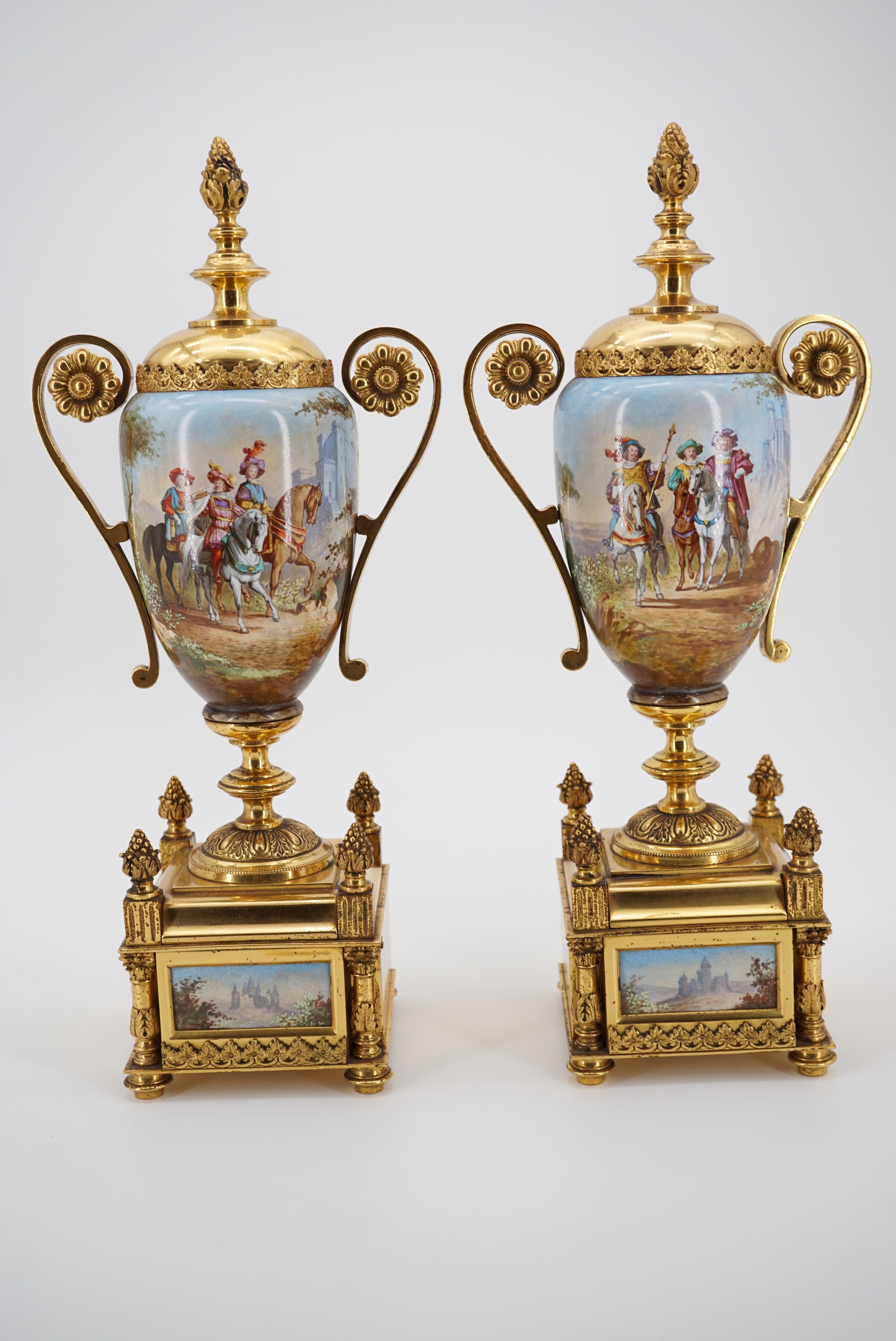 A pair of late 19th Century gilt metal mounted ceramic garniture urns, each oviform, with domed faux