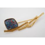 A high carat yellow metal and fire opal brooch, of loosely geometric design, having an opal cabochon