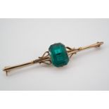 A 9ct gold bar brooch set with an emerald green glass stone, the latter of approximately 12 x 9