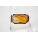 A vintage yellow metal and citrine dress ring, the rectangular citrine being domed and