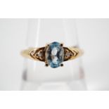 A modern blue topaz dress ring, the oval cut aquamarine of approximately .40ct, pellet-set and