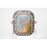 A precious white metal and opal dress ring, of Art Deco influence, having a central opal cabochon
