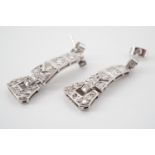 A pair of Art Deco precious white metal and diamond ear pendants, of articulated tapering form,