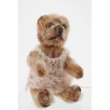 A 1930s miniature Teddy bear probably by Schuco, having articulated limbs, golden mohair, steel