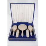 An Elizabeth II silver five piece dressing table brush and mirror set retailed by Hamilton and