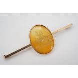 An antique yellow-metal and spessartite bar brooch, finely intaglio carved in depiction of Jacques-