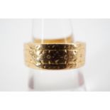 A 22ct gold band, having reeded and punched decoration, size M, 10.6g