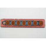 A late 19th Century Japanese bracelet for the Western market, comprising seven carved wooden plaques
