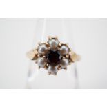 A 1960s garnet and pearl flower head cluster dress ring, pellet set and flanked by rhombus faced