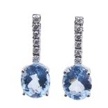 Pendientes en oro blanco con barrita de diamantes talla brillante rematada por topacio azul talla