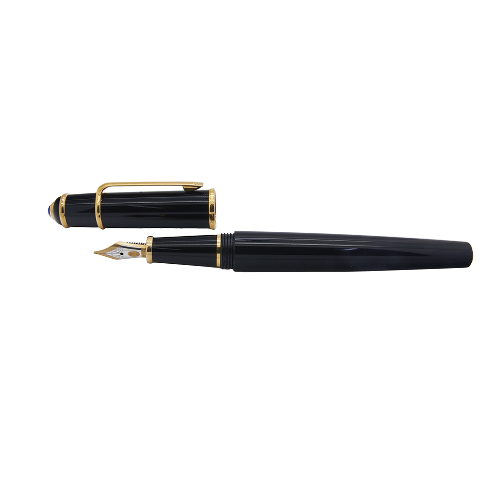 Pluma Cartier modelo "Diabolo". En composite negro con detalles en plaqué oro. Capuchón coronado por