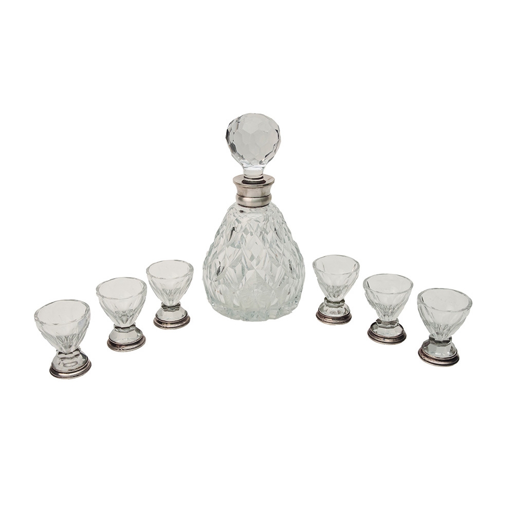 Juego de botella y seis copas en cristal tallado con decoración geométrica y plata española