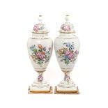 Pareja de jarrones con tapa en porcelana francesa con decoración floral policromada y fileteados