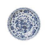 Plato en porcelana china azul y blanca con decoración de qilin en asiento y motivos florales en