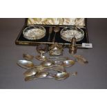 Three piece silver condiment set, cased pair of glass preserve dishes with silver spoon and knife,