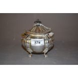 Edwardian silver teapoy of oval baluster form with a gadroon rim and hinged lid on paw feet,