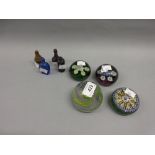 Group of four 20th Century Scottish glass paperweights together with four miniature glass bottles