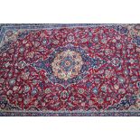 Good quality Tabriz carpet with a lobed medallion and floral design on a red ground with borders,