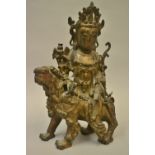 Chinese or Tibetan gilt bronze and painted figure of Quan Yin riding a foe dog,