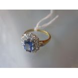 18ct Yellow gold ring set oval sapphire surrounded by brilliant cut diamonds