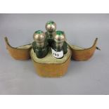 Unusual travelling perfume bottle set in leather case, the cover mounted with a shamrock,
