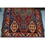 Kurdish rug with multiple medallion and borders on a wine ground,