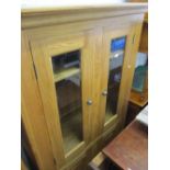 Reproduction light oak side cabinet with two glazed doors above two cupboard doors