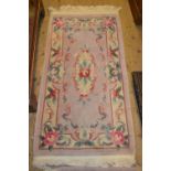 Pair of small Chinese rugs with embossed floral design on a beige ground together with a similar