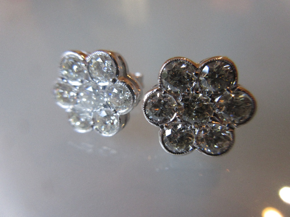 Pair of 18ct white gold seven stone diamond flowerhead stud earrings, approximately 2.