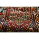 Kurdish rug with multiple medallion and borders on a wine ground, 86ins x 48ins