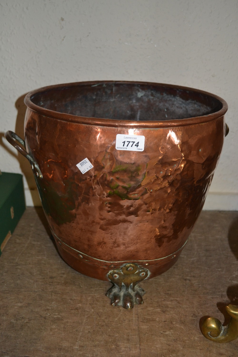 Circular copper coal bin with brass paw feet