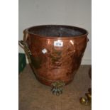 Circular copper coal bin with brass paw feet