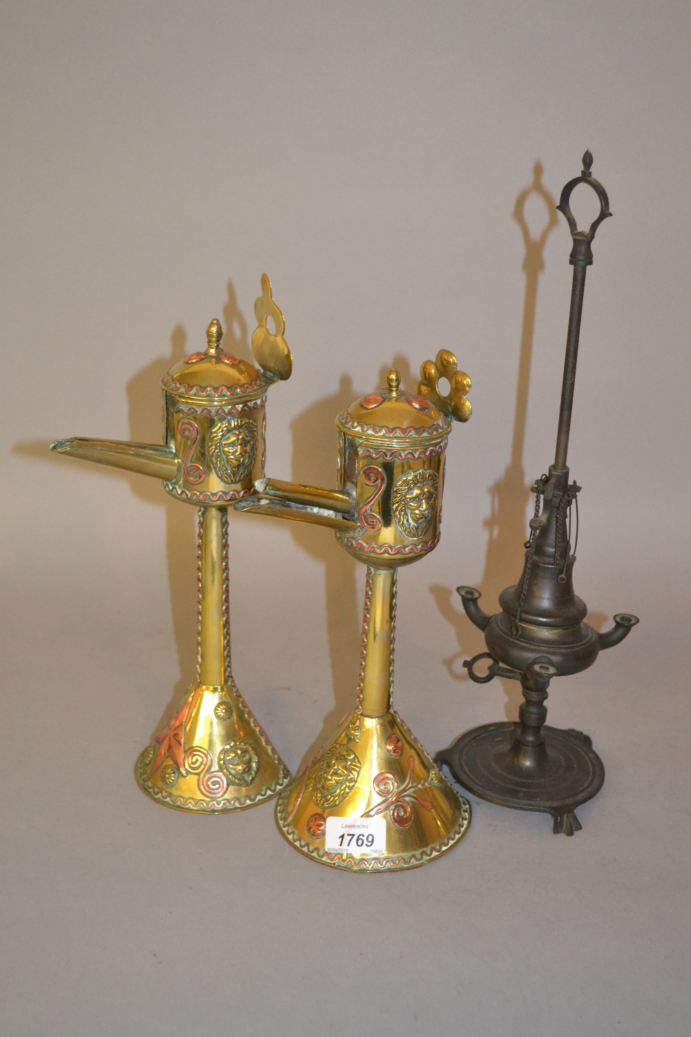 Pair of oriental brass and copper mounted oil lamps together with another Middle Eastern bronzed