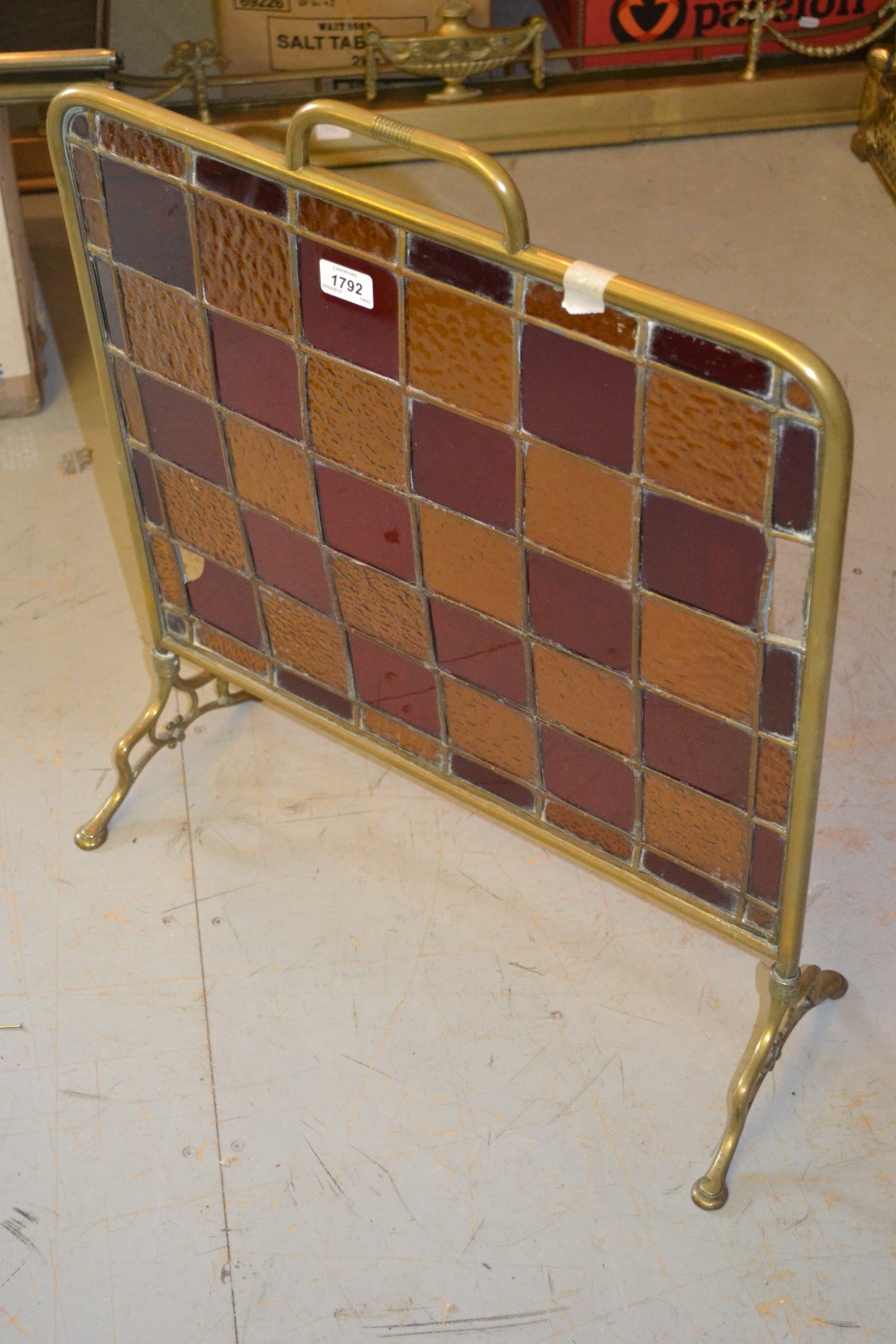 Edwardian brass and leaded glass firescreen together with an adjustable brass fire kerb