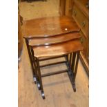 Nest of three mahogany shaped top occasional tables on slender turned supports