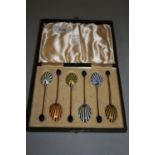 Cased set of six silver coffee spoons with enamel decorated bowls and coffee bean handles