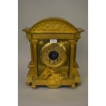 19th Century French gilt brass mantel clock of architectural form, the broken arch top inset with